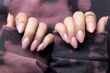 Manicured womans hands in trendy pink hoodie