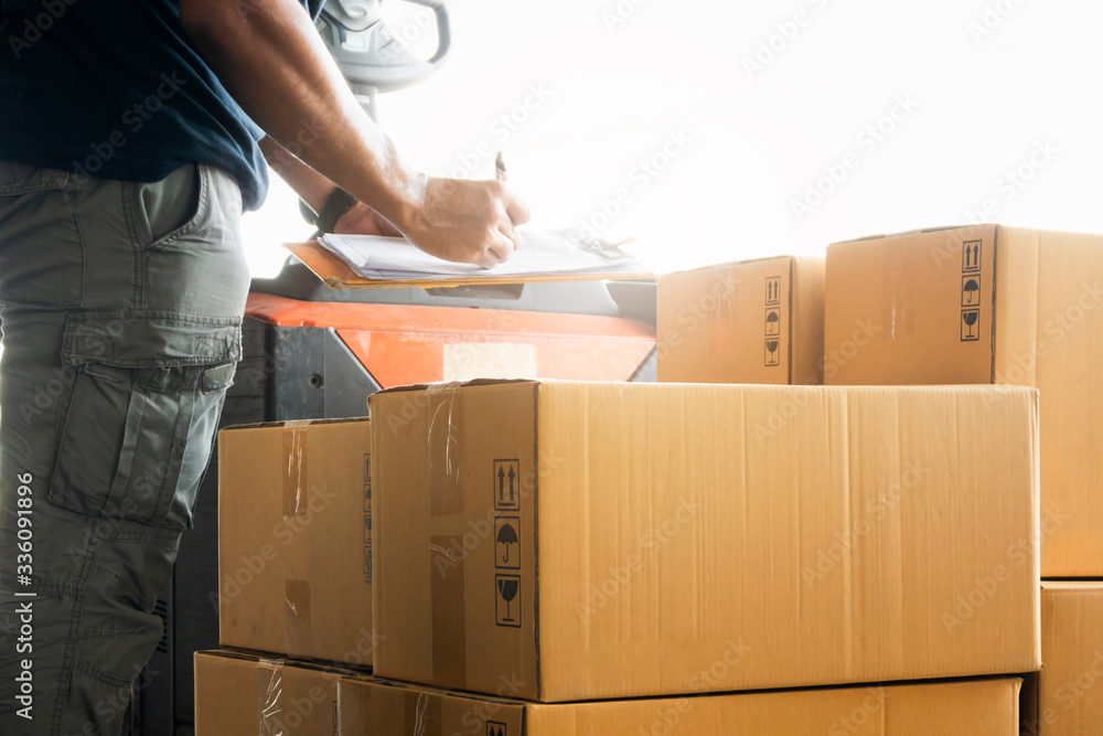 Wall mural workers courier holding clipboard writing on checklist for delivering shipment pallet goods, package