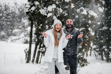 Couple playing with snow in the forest