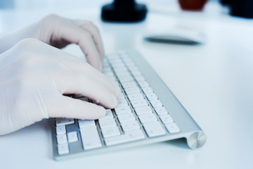 man using a computer wearing latex gloves