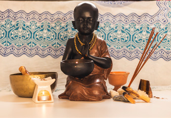 buda meditando con su incienso y mirra con mandala azul de fondo 