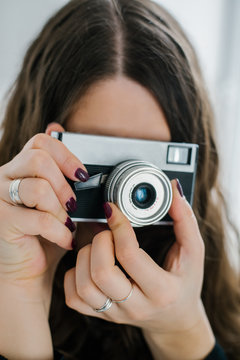 beautiful woman holding old camera at home