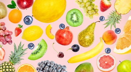 Creative photo of many different exotic tropical bright fruits on a soft pink color summer background. View from above. Bright summer fruit pattern.