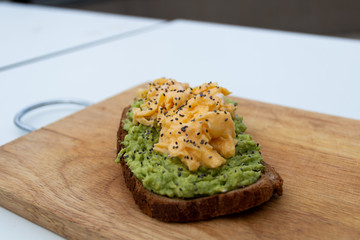 whole wheat toast with guacamole and omelette on top of a wood