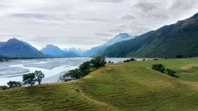 Beautiful meadows and river surrounded by mountains in Fiordland National Park near Glenorchy