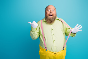 Portrait of his he nice funny funky cheerful cheery amazed man pulling suspenders showing copy space like solution ad isolated over bright vivid shine vibrant blue turquoise green color background