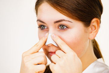 Woman applying pore strips on nose