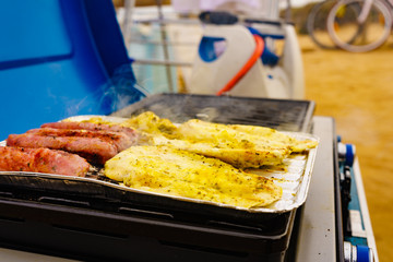 Sausages and chicken meat on grill