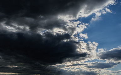 Naklejka na ściany i meble Blue sky with dark clouds. Nature background.