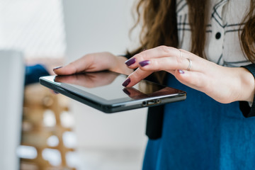Young woman uses tablet while relaxing at home
