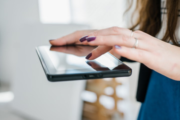 Young woman uses tablet while relaxing at home