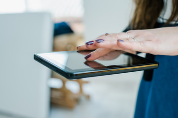 Young woman uses tablet while relaxing at home