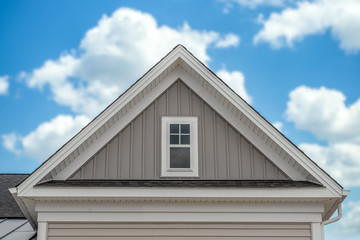 In focus gable on a newly built single family house with white fascia, common rafter, soffit,...