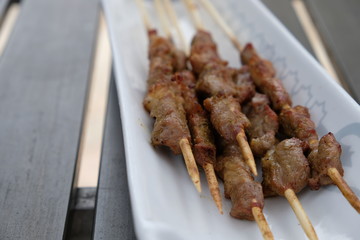 close up several skewers of lamb kebabs in plate on table. blur background © Robert