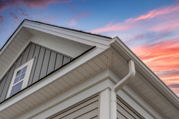 White frame gutter guard system, with gray horizontal and vertical vinyl siding fascia, drip edge,...
