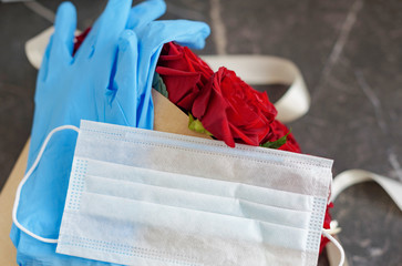 contactless delivery - face mask medical glove and bouquet of red roses, the concept of quarantine...