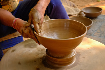 Pottery - skilled wet hands of potter shaping the clay on potter wheel. Pot, vase throwing....