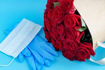 contactless delivery - face mask medical glove and bouquet of red roses, the concept of quarantine...