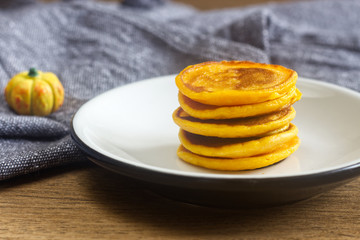 Homemade pumpkin pancakes on the white plate.