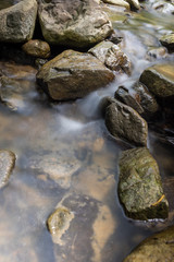Fototapeta na wymiar Photo of nature - Long exposure of a mountain stony creek inside in the forest. Small mountain rocky river.