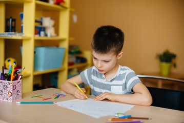 A school-age boy does homework at home. Training at school