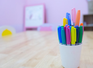 Close up selective focus of Colour Pens Markers in A Cup on the white wooden with copy space. Back to school concept, Offices stationary concept