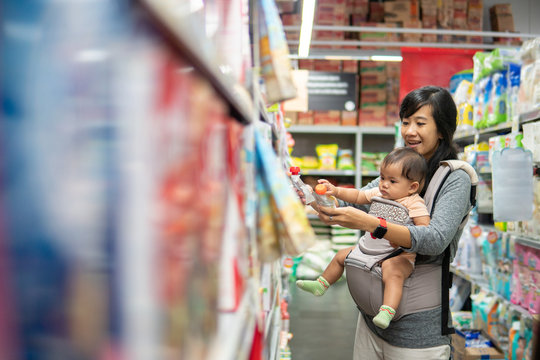 asian Mother and baby shopping in the supermarket. grocery store shopping