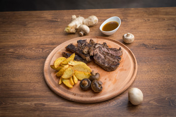 Fototapeta na wymiar Steak with grilled vegetables and seasoning on serving plate