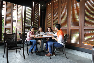 Group young asian malay man woman at rustic wooden cafe table meet talk discuss business study
