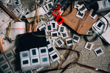 Abandoned industrial building with photos and film strips on the floor. 