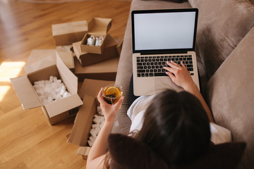 Woman shopping online at home use laptop. Woman work on laptop and drink tea. Quarantine time....