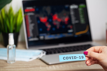 Woman holding the inscription covid-19 on the background of the virus spread map of the world