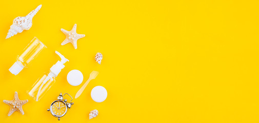 Plastic packaging. Rides set on a yellow background. Plastic bottles, watches, toothbrushes, containers for lenses and dental floss in a sealed bag. Going on vacation.top view, copy space