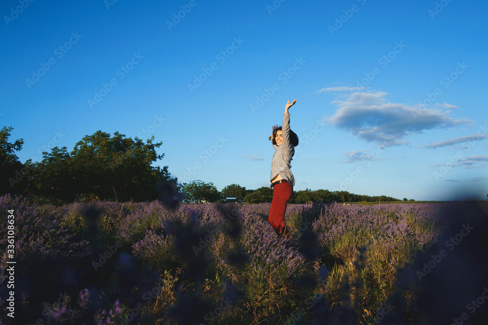 Wall mural happy woman jumping in lavender field