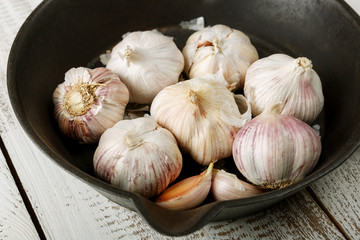 garlic on a black plate and white background

