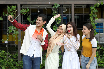 Group young asian chinese malay man woman wearing headscarf outdoor friend student colleague happy exited take self portrait selife on phone