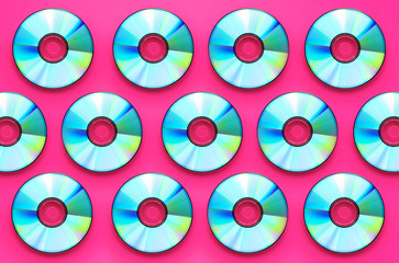 Shiny compact disk or DVD on pink background