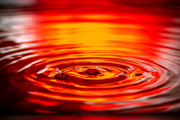 Wasser tropfen auf wasser rot Hintergrund beleuchtung mit kleinen wellen 