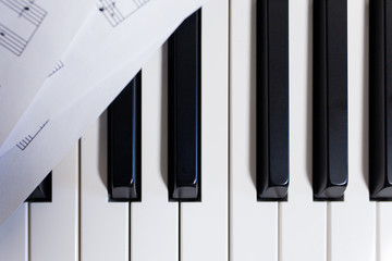 Piano and modern music sheets close up