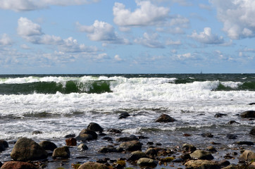 Seaview with rolling waves and cumulus clouds on the sky