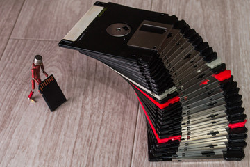 small handmade human figure from resistors demonstrates advantages of modern flash storage versus old fashioned 3.5 inch diskettes