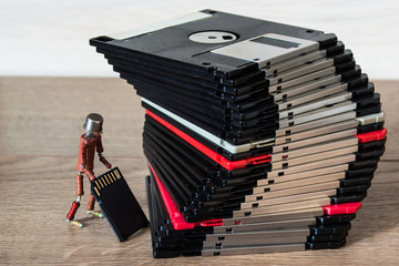 small handmade human figure from resistors demonstrates advantages of modern flash storage versus old fashioned 3.5 inch diskettes