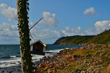 Bird feeder hanging on an old pole on the coastline