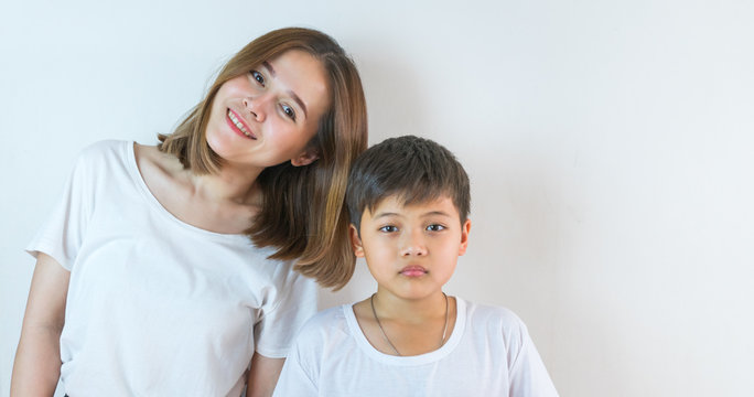 Asian mother and son wear a white T-shirt and are smiling.