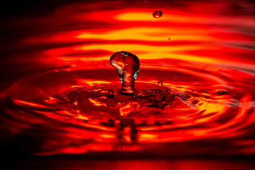 Wasser tropfen auf wasser rot Hintergrund beleuchtung mit kleinen wellen 