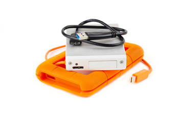 Padded orange hard disk drive. Portable silver HDD on top of its protection housing.