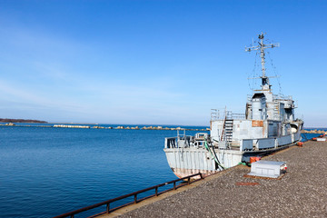 old abandoned warship in the harbor near the pier