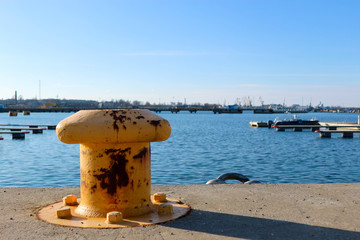 Fototapeta premium Yellow mooring pedestal on the pier under blue sky