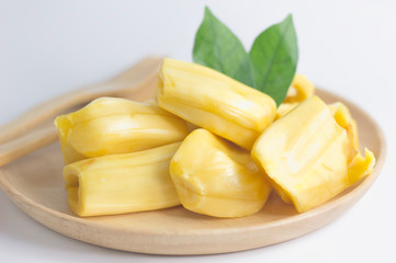 Fresh jackfruit slices on a wood plate. sweet yellow jackfruit ripe. vegetarian, vegan, raw food. Exotic tropical fruit - isolated background