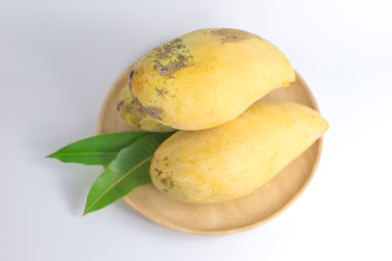 Delicious ripe mango with green leaf on white background.